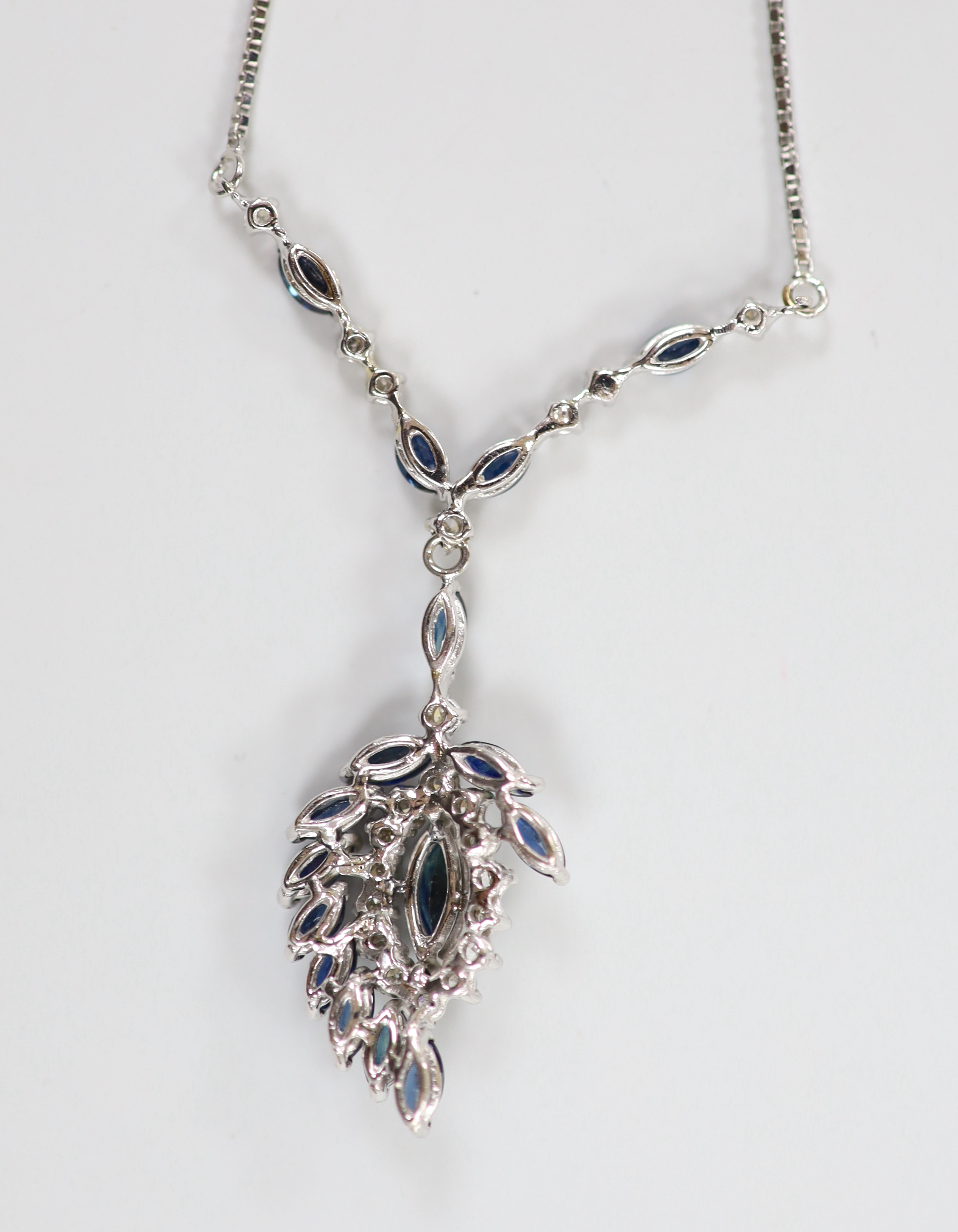 A modern 750 white metal, sapphire and diamond cluster set drop pendant necklace, overall 52cm, gross weight 9.3 grams